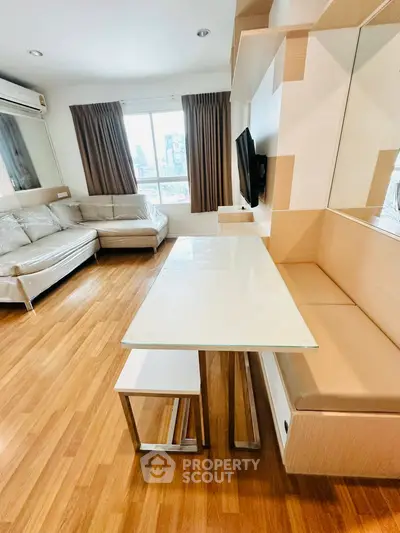 Modern living room with sleek furniture and city view, featuring a cozy dining area and stylish decor.