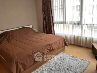 Spacious bedroom with large windows and cozy decor in modern apartment