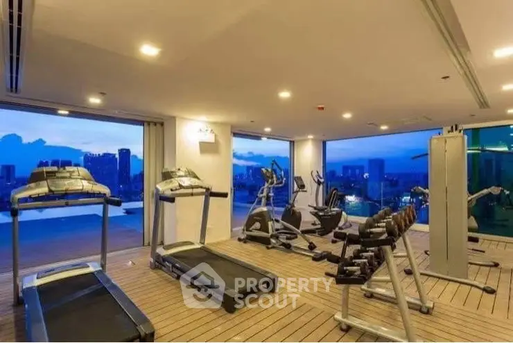 Luxury gym with panoramic city views and modern fitness equipment.