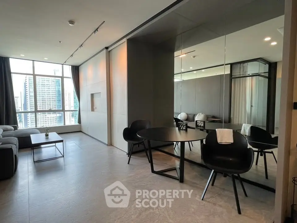 Modern living room with city view, sleek furniture, and large windows in a high-rise apartment.