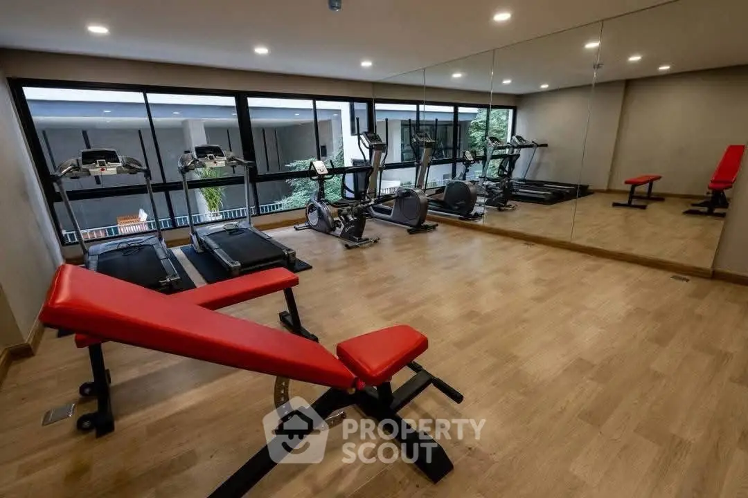 Modern gym with state-of-the-art equipment and mirrored walls in a luxury apartment complex.