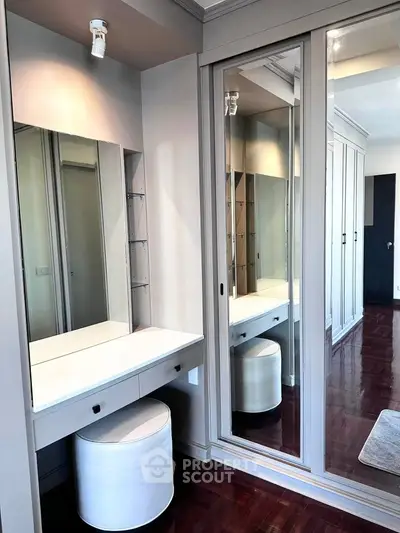 Elegant bedroom with mirrored wardrobe and stylish vanity area