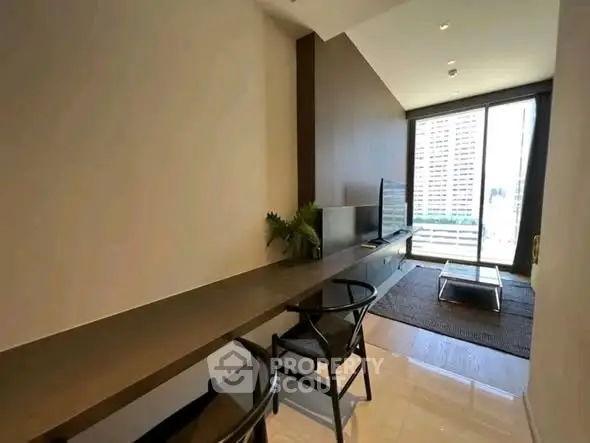 Modern living room with sleek furniture and large window offering city views.