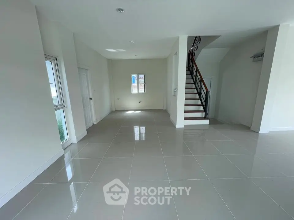 Spacious modern living room with tiled flooring and staircase in a bright open layout