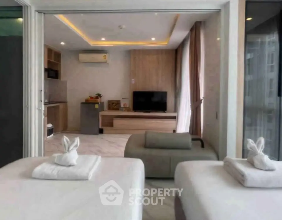 Modern living room with open layout and stylish decor, featuring a cozy seating area and sleek kitchen.
