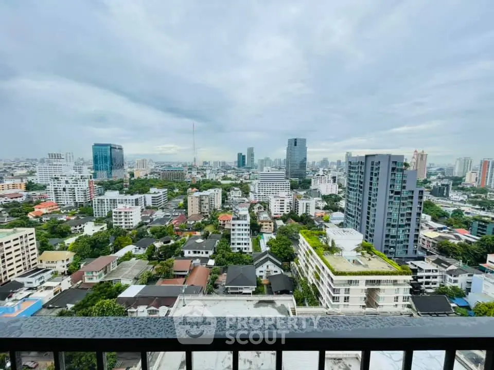 Stunning cityscape view from a high-rise balcony showcasing urban skyline and lush greenery.
