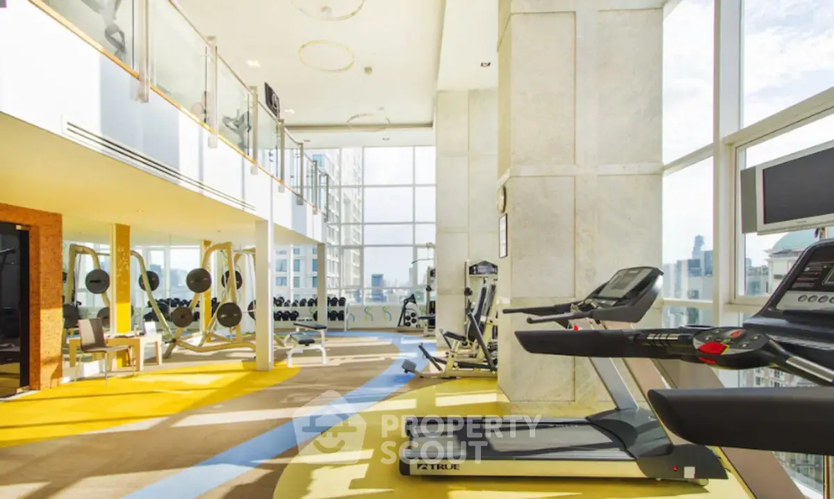 Luxurious high-rise gym with panoramic city views and modern fitness equipment.
