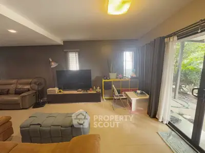 Cozy living room with modern decor and garden view through sliding doors.