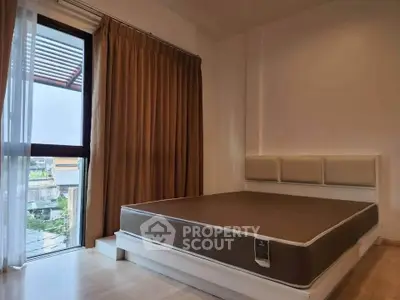 Spacious bedroom with large window and modern decor