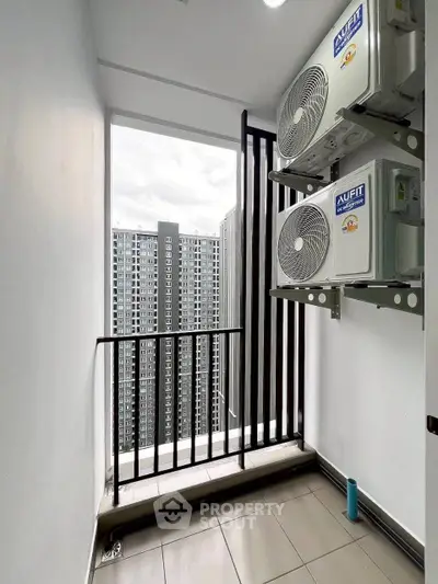 Modern apartment balcony with city view and air conditioning units, perfect for urban living.