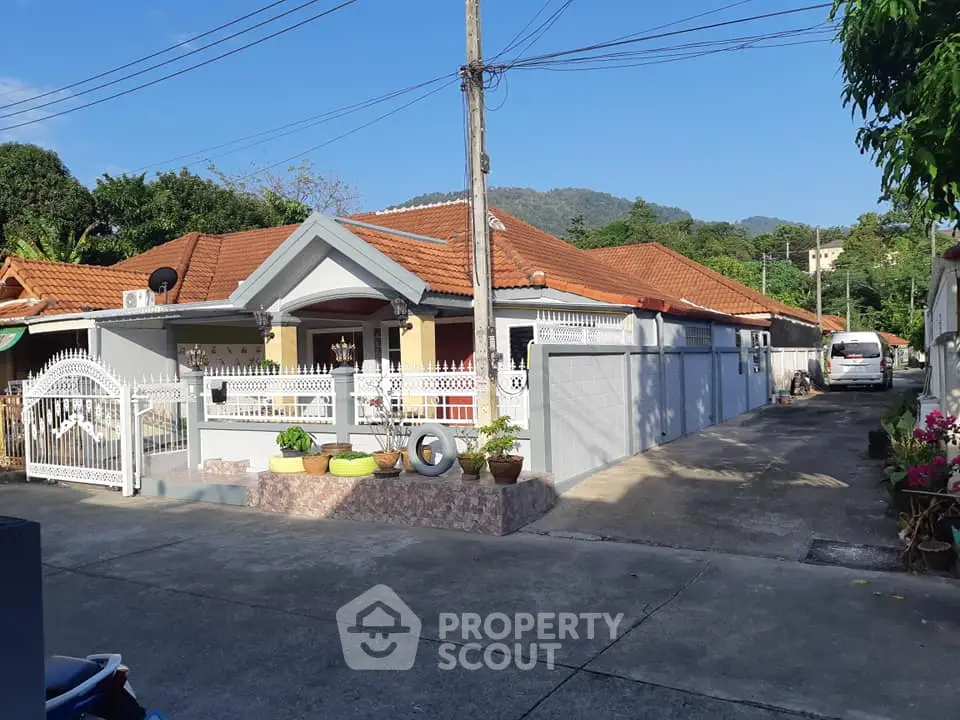 Charming suburban house with red roof and spacious driveway in tranquil neighborhood.