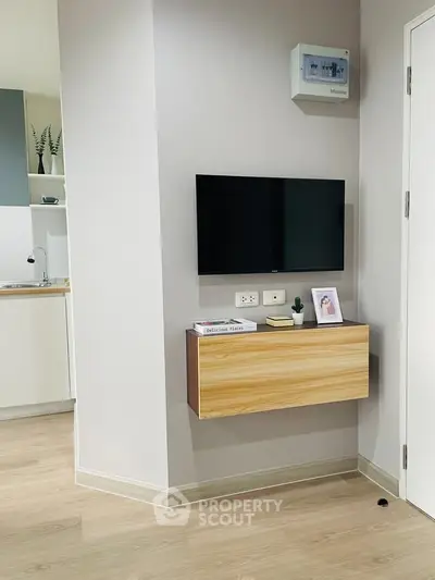 Modern living room with wall-mounted TV and sleek wooden cabinet