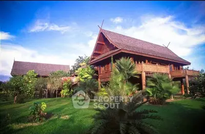 Stunning traditional wooden house with lush garden and tropical landscape