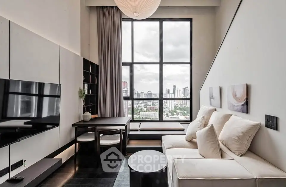 Modern living room with large windows and city view, featuring sleek furniture and stylish decor.