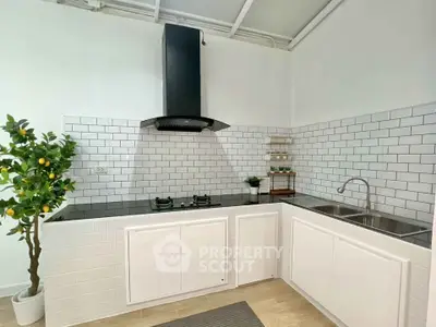 Modern kitchen with sleek black gas stove and white subway tiles