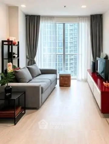 Modern living room with large window and stylish furniture in high-rise apartment.