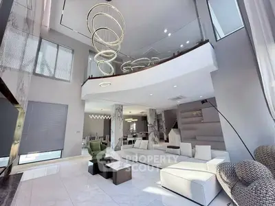 Luxurious modern living room with high ceilings and elegant lighting fixtures.