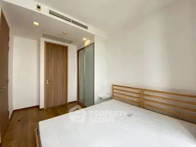 Spacious minimalist bedroom with wooden flooring and modern design