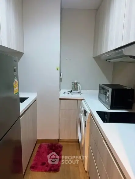 Modern compact kitchen with sleek appliances and wooden cabinetry