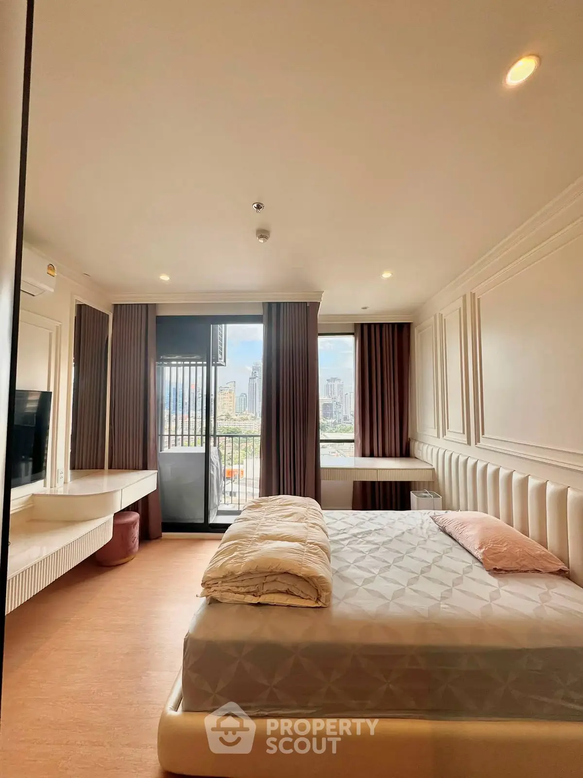 Luxurious bedroom with city view and elegant decor, featuring a cozy bed and large windows.