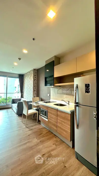 Modern open-layout kitchen with sleek appliances and cozy living area, perfect for urban living.