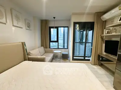 Modern studio apartment with city view, featuring cozy living area and balcony access.