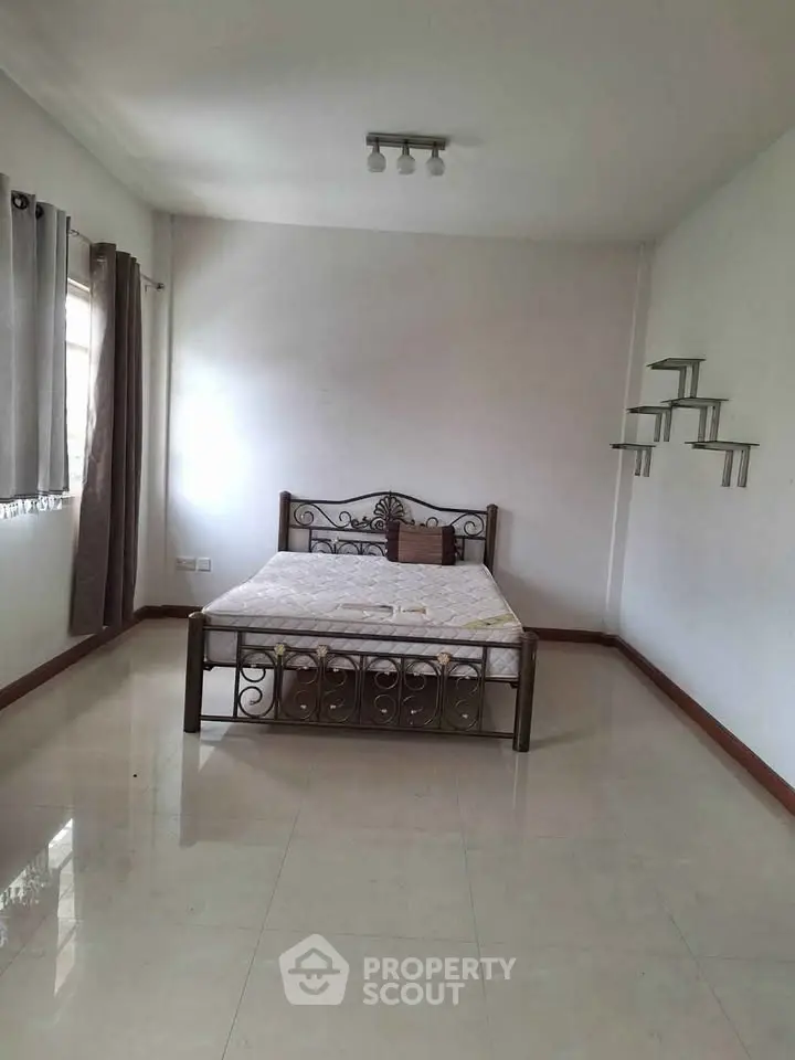 Spacious bedroom with elegant metal bed frame and minimalist decor.