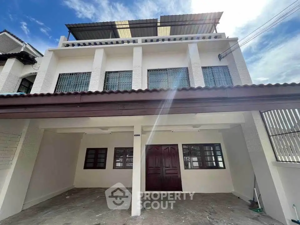 Spacious three-story townhouse with modern facade and ample parking space