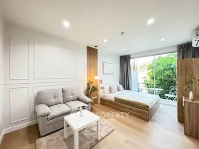 Modern studio apartment with cozy living area and balcony view