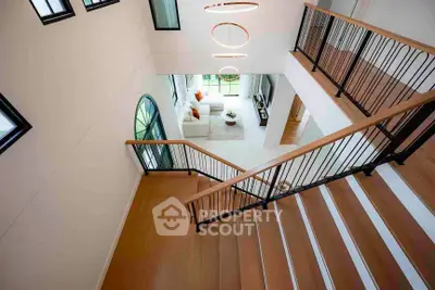 Elegant modern staircase with view of spacious living room and stylish decor