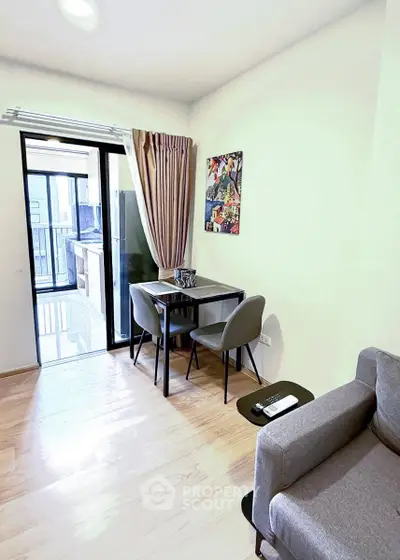 Modern living room with dining area and balcony access in a stylish apartment.