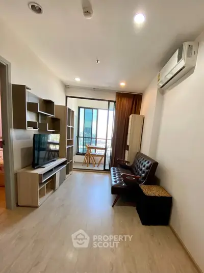 Modern living room with sleek furniture and balcony view in a stylish apartment.