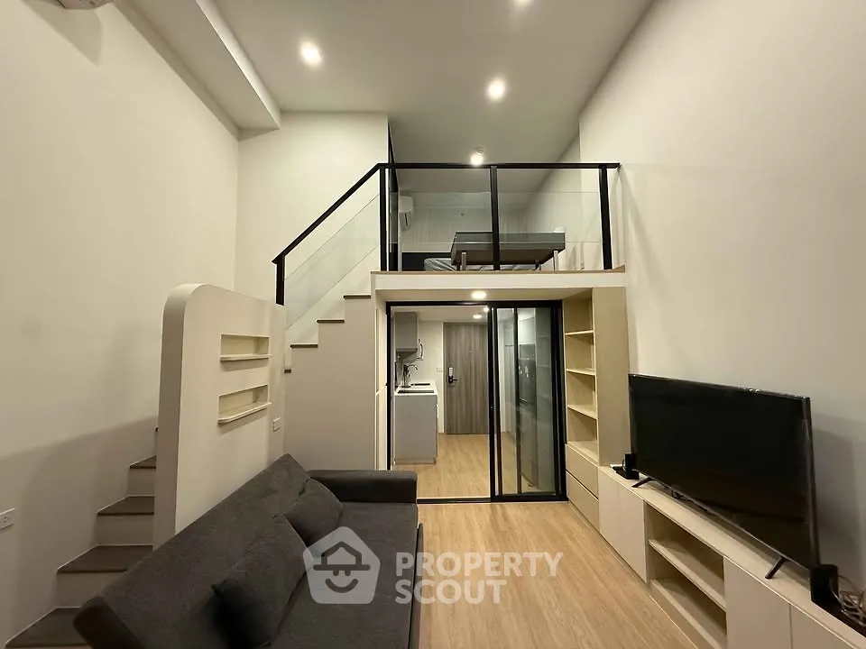 Modern loft-style living room with mezzanine, sleek design, and cozy ambiance.