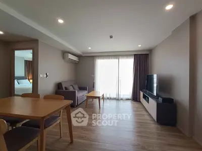 Spacious modern living room with wooden flooring and natural light