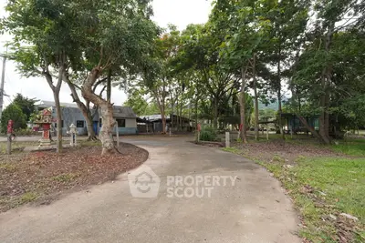 Charming rural property with lush greenery and rustic buildings, perfect for serene living.
