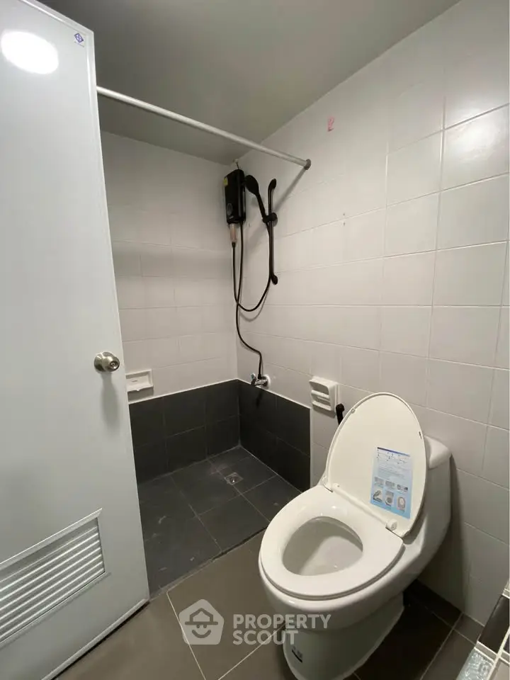 Modern bathroom with sleek design and efficient layout, featuring a shower and toilet.