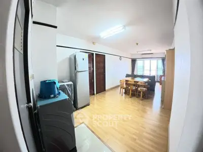 Spacious open-plan living area with dining set and modern appliances, perfect for family gatherings.