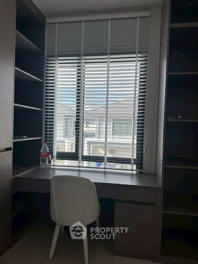 Modern study room with desk, chair, and window view in a stylish home.