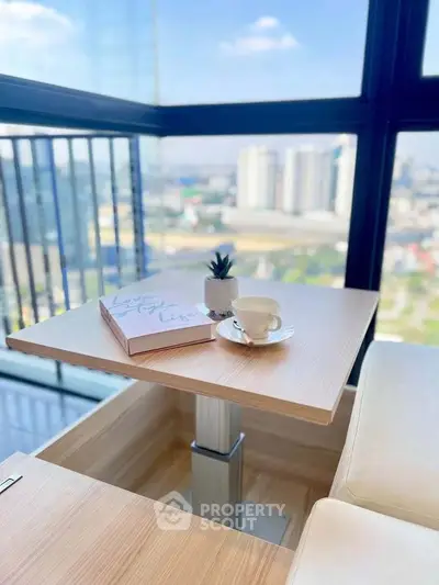 Modern balcony with city view, featuring a cozy table setup with coffee and a book, perfect for relaxation.