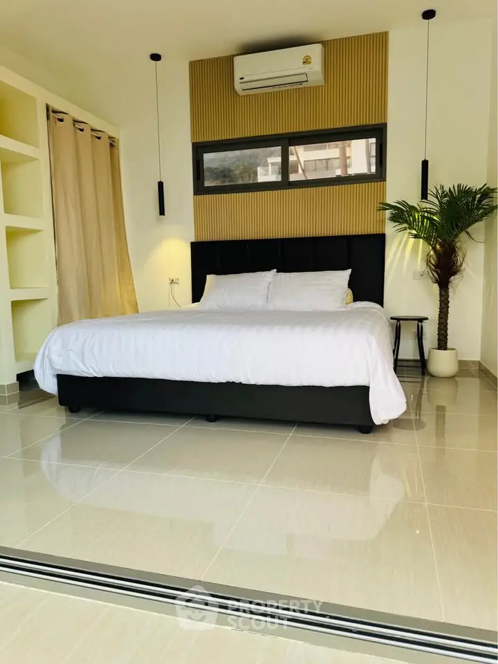 Modern bedroom with stylish decor and large bed, featuring sleek tile flooring and natural light.