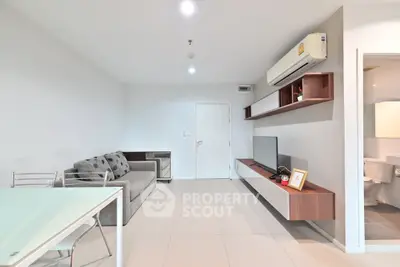 Modern living room with sleek furniture and wall-mounted TV in a stylish apartment.
