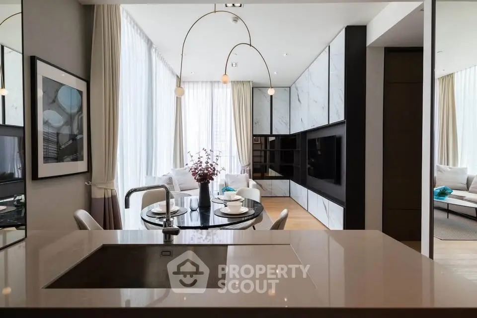 Luxurious modern living room with open kitchen and elegant dining area, featuring sleek design and ample natural light.
