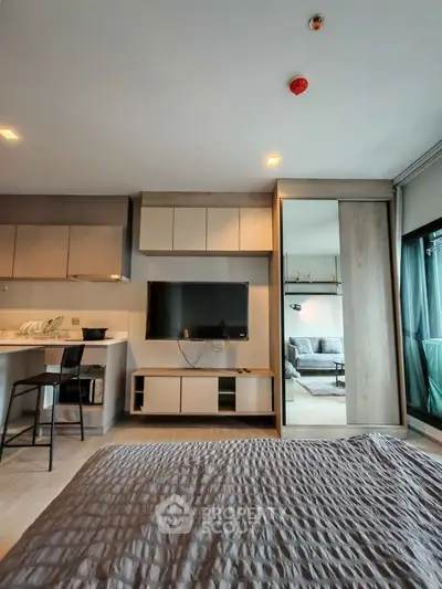 Modern studio apartment with open layout, featuring sleek kitchen and cozy living area.