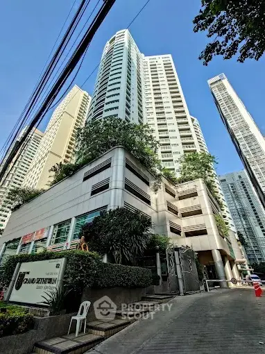 Stunning high-rise building with modern architecture and lush greenery in urban setting.