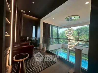 Luxurious modern living room with high ceilings and pool view, featuring elegant lighting and stylish decor.