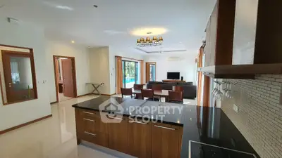 Spacious open-plan living room with modern kitchen and pool view