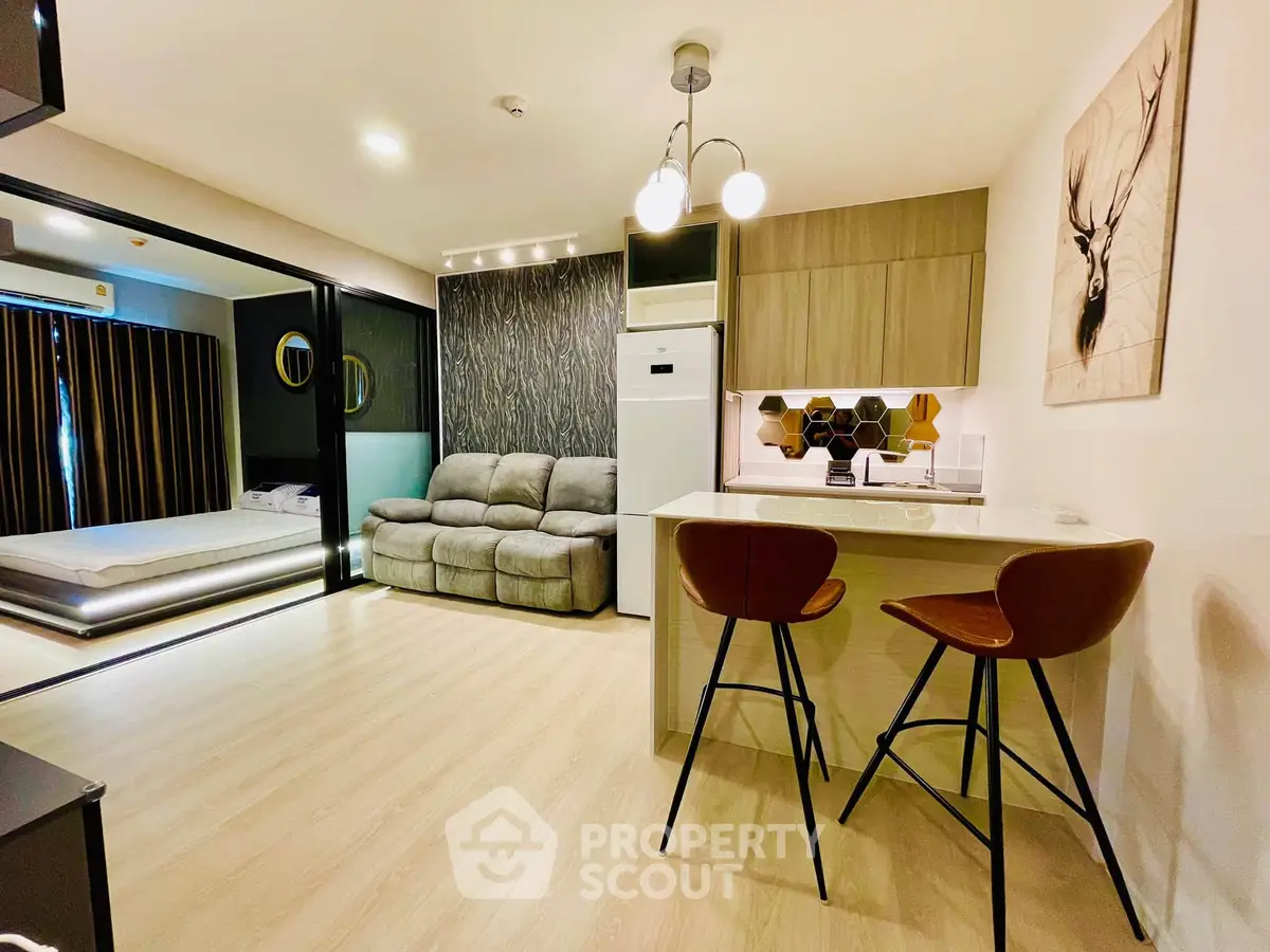 Modern open-plan living room with stylish kitchen and cozy bedroom in a chic apartment.