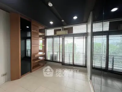 Spacious room with large windows and built-in shelving, ideal for modern living.