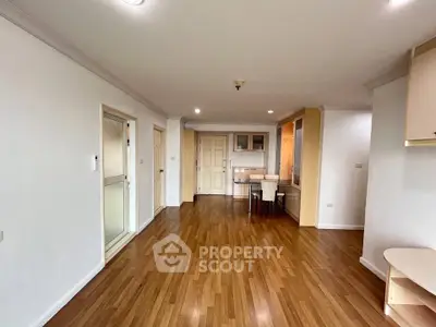 Spacious open-plan living area with wooden flooring and modern dining setup.