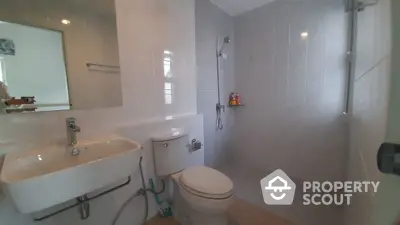 Modern bathroom with sleek fixtures and neutral tiles in a real estate property.